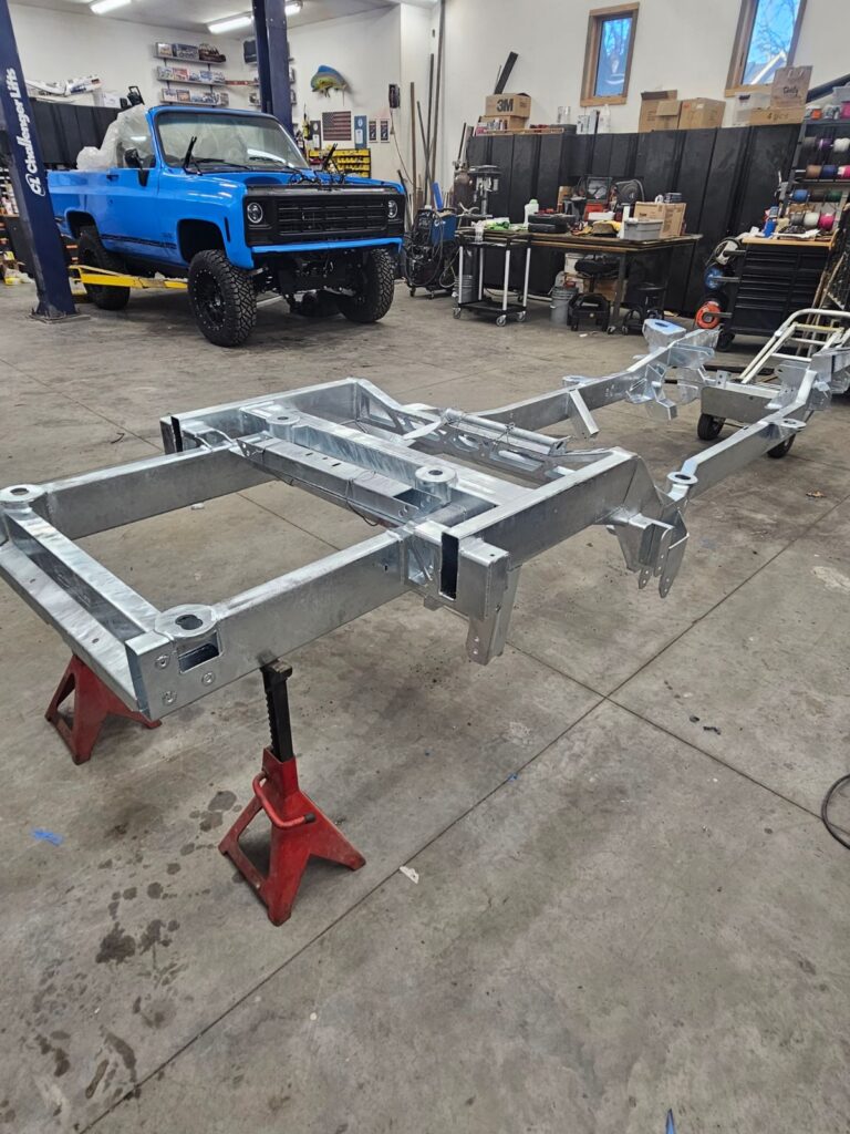 Bare hot-dip galvanized Frame-Werx chassis on stands in the shop