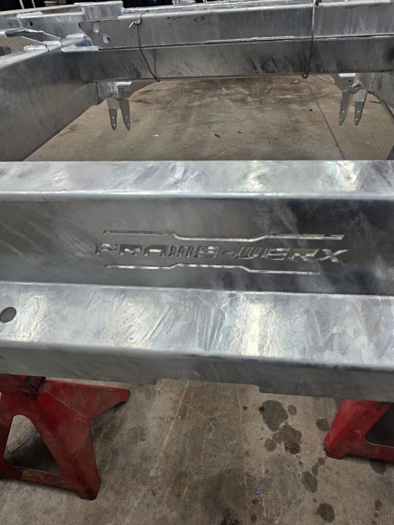 Frame-Werx name stamped into a hot-dip galvanized chassis rail