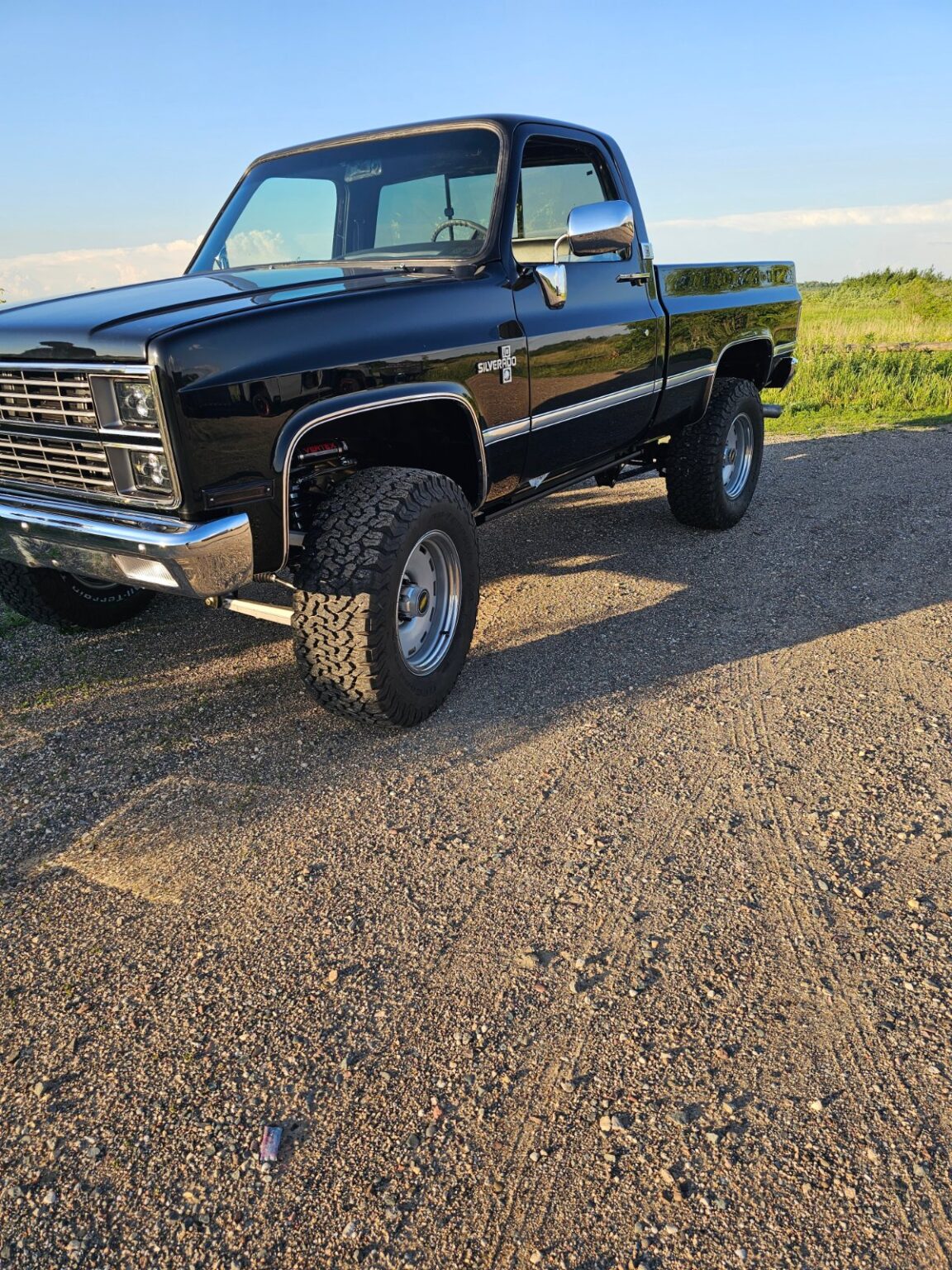 Black square-body Chevy K10 on a Frame-Werx chassis at golden hour