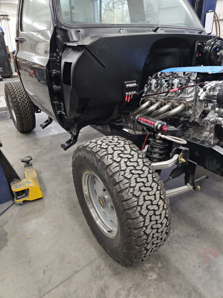 Independent front suspension corner on a Frame-Werx chassis with reservoir coilover and control arms