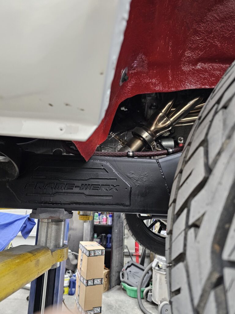 FRAME-WERX stamped chassis rail under the 85 Chevy extended cab, red wheel well and headers above