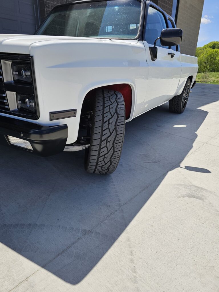 Lowered stance of the white 85 Chevy extended cab on a two-wheel-drive Frame-Werx chassis