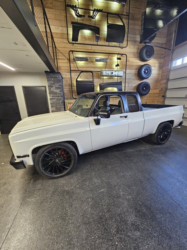 White 85 Chevy extended cab on a Frame-Werx chassis in the showroom