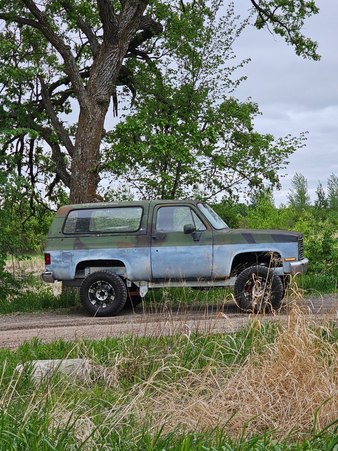 CUCV K5 Blazer on a Frame-Werx chassis on a gravel road by the lake